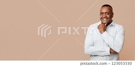 Positive mature african man touching his chin, orange background Positive mature african man touching his chin, orange background 123053330
