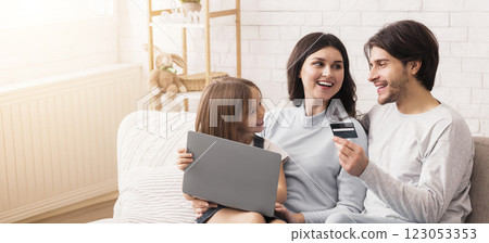 Daddy, Please Buy It. Happy Family Of Three Making Online Shopping, Cute Little Girl Holding Laptop And Her Father Holding Credit Card, Panorama 123053353