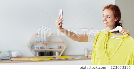 Shopping, Fashion, Style, Technology And People Concept. Happy woman taking selfie at showroom, holding shirt on hanger Shopping, Fashion, Style, Technology And People Concept. Happy woman taking selfie at showroom, holding shirt on hanger 123053395