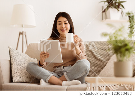 Online Education Concept. Girl Using Tablet and Drinking Tea, Resting at Home 123053493