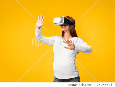 Excited Pregnant Woman Using Virtual Reality Headset Playing Videogame Standing Over Pink Background. Studio Shot 123053541
