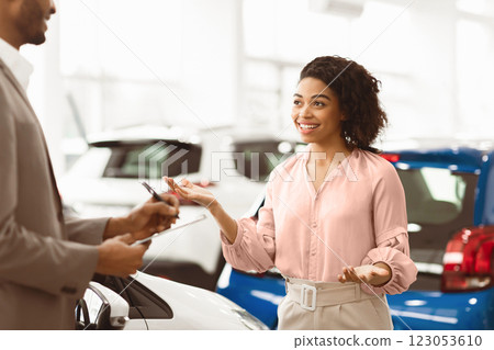 Car Buyer. Cheerful Lady Customer Talking With Auto Seller Guy Standing In Automobile Dealership Shop. Selective Focus 123053610
