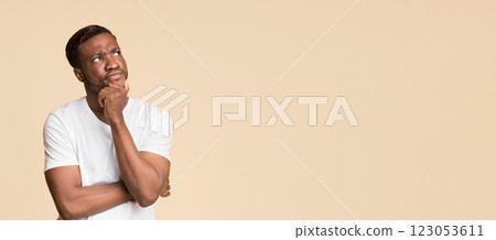 Pensive Afro Man Thinking Touching Chin Standing Over Yellow Studio Background. Panorama With Free Space 123053611