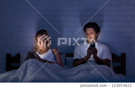 Infidelity Concept. Unfaithful Girlfriend Chatting On Phone Lying With Boyfriend In Bed At Night. Low Light, Selective Focus 123053621