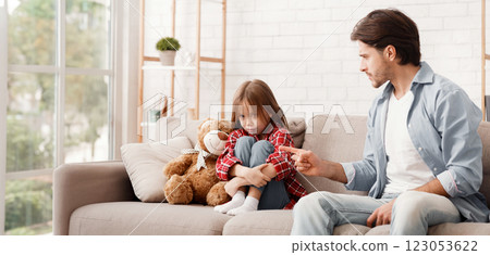 Father scolding his badly behaved little daughter, sitting on sofa at home, child behaviour problems Father scolding his badly behaved little daughter, sitting on sofa at home, child behaviour problems 123053622
