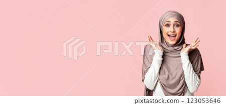 Wow. Surprised muslim girl in headscarf opened mouth in amazement over pink studio background, panorama with free space Wow. Surprised muslim girl in headscarf opened mouth in amazement over pink studio background, panorama with free space 123053646