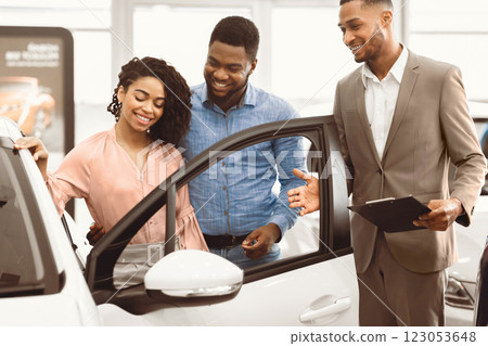 Car Selling Manager Showing Luxury Car To Buyers Helping Them Choose Family Auto In Dealership Shop Car Selling Manager Showing Luxury Car To Buyers Helping Them Choose Family Auto In Dealership Shop 123053648