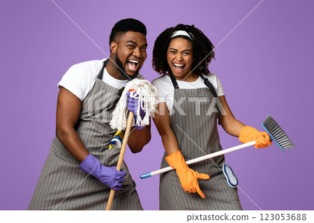 Cleaning Fun. Playful Black Couple Using Mop As Microphones, Having Fun During Tidying, Singing Together Over Pink Background, Copy Space Cleaning Fun. Playful Black Couple Using Mop As Microphones, Having Fun During Tidying, Singing Together Over Pink Background, Copy Space 123053688