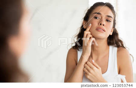 Skin Problem. Depressed Woman Touching Pimple On Face Looking At Mirror In Modern Bathroom. Facial Skin Issues, Medical Care And Treatment Concept. Selective Focus Skin Problem. Depressed Woman Touching Pimple On Face Looking At Mirror In Modern Bathroom. Facial Skin Issues, Medical Care And Treatment Concept. Selective Focus 123053744