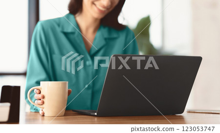 Coffee Time. Unrecognizable smiling girl using laptop and holding mug with hot drink beverage, panorama Coffee Time. Unrecognizable smiling girl using laptop and holding mug with hot drink beverage, panorama 123053747