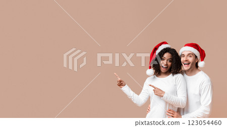 Seasonal Sales. Excited millennial couple pointing aside at free space for your advertisement over yellow background, panorama 123054460