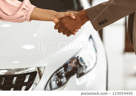 Car Buyer And Auto Seller Shaking Hands Buying Automobile In Luxury Dealership Store. Closeup, Cropped, Free Space Car Buyer And Auto Seller Shaking Hands Buying Automobile In Luxury Dealership Store. Closeup, Cropped, Free Space 123054495
