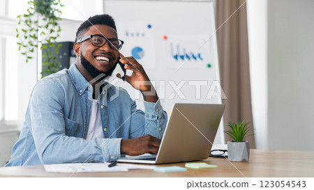 Great news. Happy african american businessman received good news on phone, his project received financing 123054543