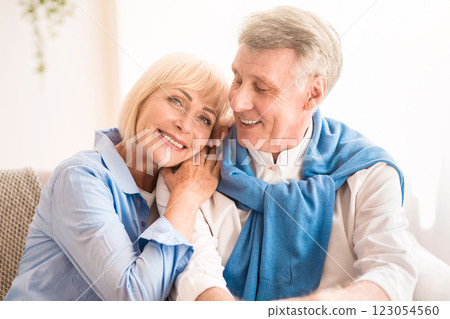 Happy mature couple enjoying time at home and relaxing on sofa 123054560