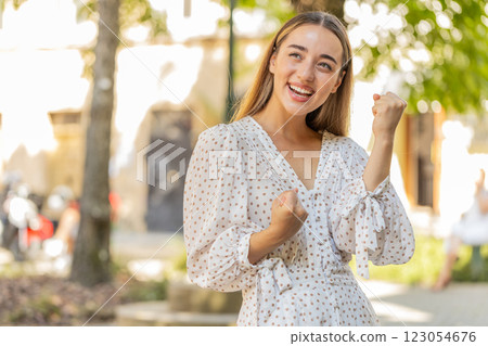Excited happy young woman shouting celebrating success winning achievement good news on city street Excited happy young woman shouting celebrating success winning achievement good news on city street 123054676