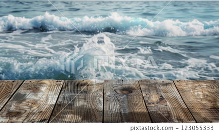 A wooden plank sits in front of a blurred image of ocean waves, creating a tranquil and inviting scene. 123055333