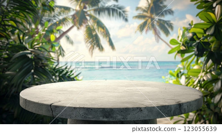 A round stone table top with a blurred background featuring palm trees and a tropical beach. 123055639