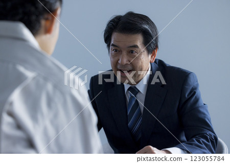 A middle-aged businessman giving a presentation with a serious expression 123055784