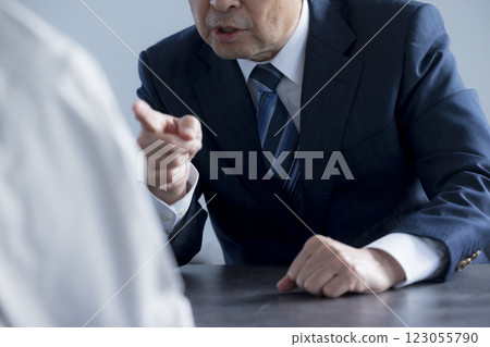 A middle-aged businessman giving a presentation with a serious expression A middle-aged businessman giving a presentation with a serious expression 123055790