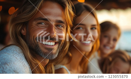 A family gathers on the beach during sunset, sharing cheerful smiles and laughter. Their happiness radiates as they capture a perfect moment together, surrounded by warm light. 123055870