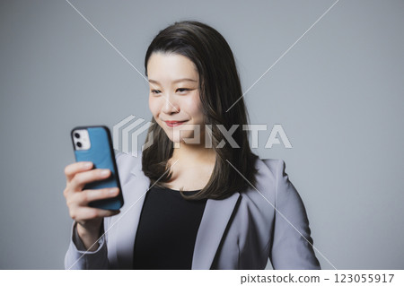 A woman watching a smartphone 123055917