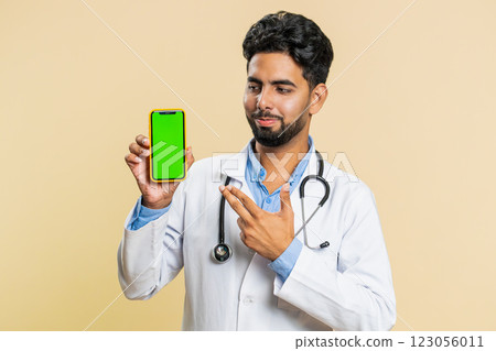Indian doctor man holds smartphone with green screen chroma key mock up recommend good application Indian doctor man holds smartphone with green screen chroma key mock up recommend good application 123056011