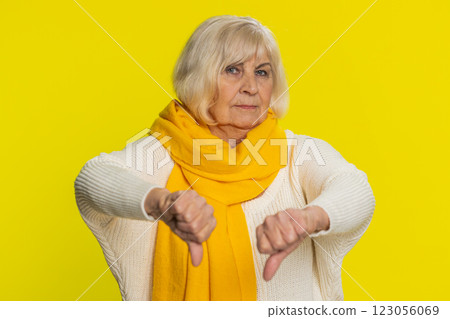 Upset grandmother woman shows thumbs down gesture disapproval dissatisfied dislike negative feedback Upset grandmother woman shows thumbs down gesture disapproval dissatisfied dislike negative feedback 123056069