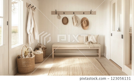 This inviting entryway showcases a simple wooden bench adorned with hats, complemented by woven baskets and a soft rug. Natural light fills the space, enhancing its warm and minimalistic design. This inviting entryway showcases a simple wooden bench adorned with hats, complemented by woven baskets and a soft rug. Natural light fills the space, enhancing its warm and minimalistic design. 123056131