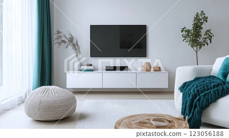 A stylish living room features a mounted flat-screen television above a minimalist white cabinet 123056188