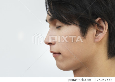 20 多歲男性的側面照，閉上眼睛（焦點在眼睛上）男性美容和皮膚護理圖像肖像 123057358