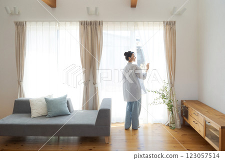 女人在客廳拉開窗簾 123057514