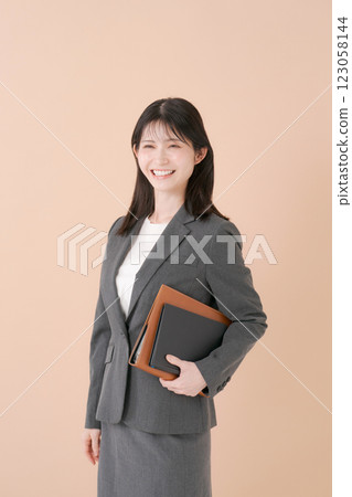 Smiling business woman holding a file Smiling business woman holding a file 123058144