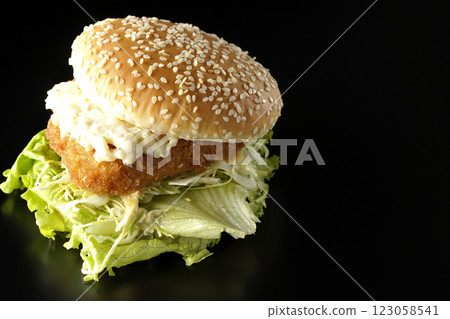 Tartar fish burger photographed against a black background Tartar fish burger photographed against a black background 123058541