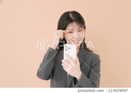 一名女子正在用內建攝影機檢查自己的妝容 123059097