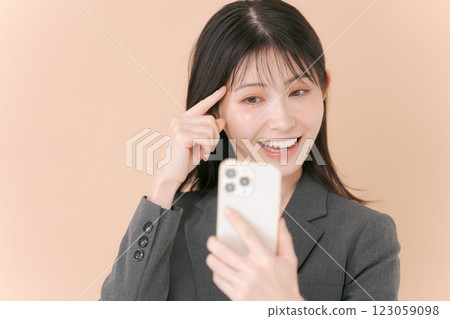 一名女子正在用內建攝影機檢查自己的妝容 123059098