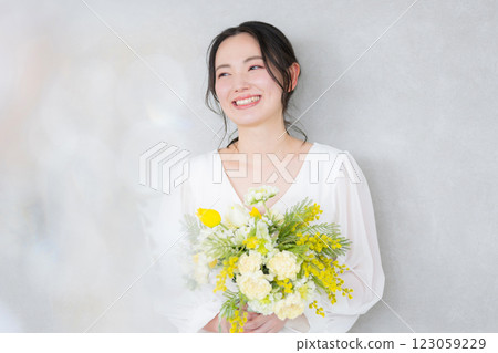 一個可愛的女人拿著一束黃色的花朵春天、美麗和美麗的圖像 一個可愛的女人拿著一束黃色的花朵春天、美麗和美麗的圖像 123059229