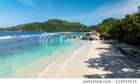 Rocky formations along a pristine beach surrounded by lush green hills. Baie Lazare. Seychelles, Mahe. Rocky formations along a pristine beach surrounded by lush green hills. Baie Lazare. Seychelles, Mahe. 123059324
