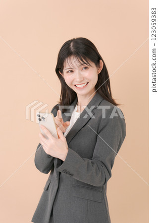 有一套衣服的一名婦女與智能手機 有一套衣服的一名婦女與智能手機 123059383