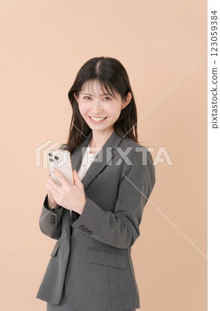 有一套衣服的一名婦女與智能手機 有一套衣服的一名婦女與智能手機 123059384