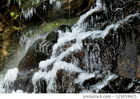Water flowing over rocks of a frozen waterfall 123059425