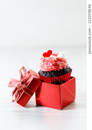 Chocolate cupcake with pink cream and heart shaped sprinkles. 123059636