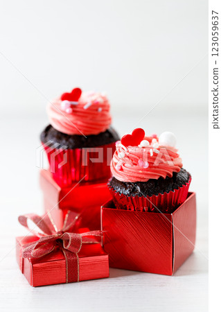 Chocolate cupcakes with pink cream and heart shaped sprinkles. Chocolate cupcakes with pink cream and heart shaped sprinkles. 123059637