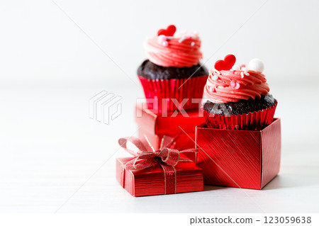 Chocolate cupcakes with pink cream and heart shaped sprinkles. Chocolate cupcakes with pink cream and heart shaped sprinkles. 123059638