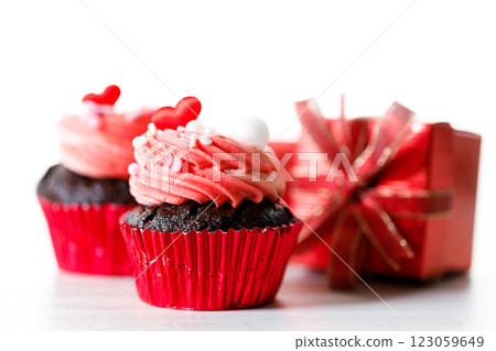 Chocolate cupcakes with pink cream and heart shaped sprinkles. 123059649