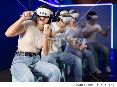 Girl in vr glasses with joysticks playing a video game 123060375