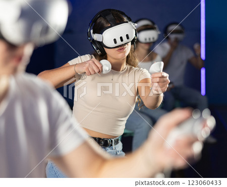 Girl in vr glasses with joysticks playing a video game 123060433