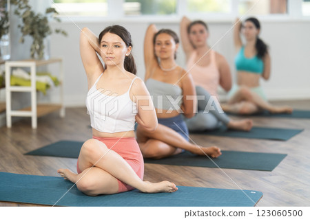 Group of women of working out practice Lord of fishes pose Group of women of working out practice Lord of fishes pose 123060500