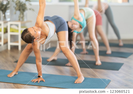 Women meditates in yoga pose parshvottanasana in gym 123060521