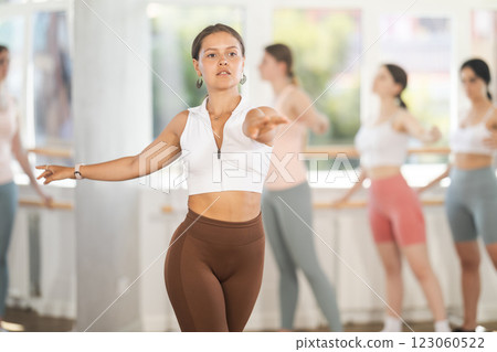 Young female dancer performing solo dance at ballet class 123060522