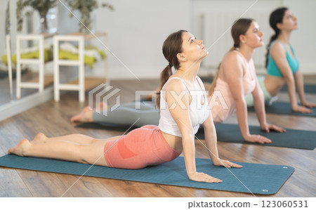 Young girl doing Upward Facing Dog pose in yoga studio Young girl doing Upward Facing Dog pose in yoga studio 123060531
